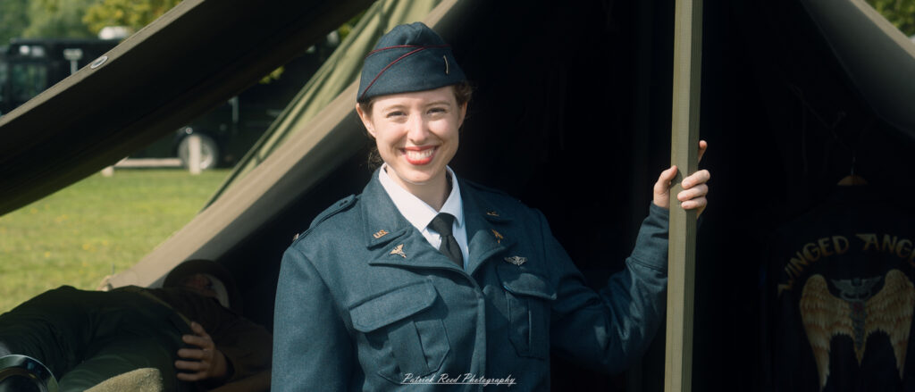 A resolute female Army Air Nurse standing confidently in front of her tent. Dressed in her military uniform, she exudes professionalism and dedication, symbolizing the vital role of women in wartime medical care.